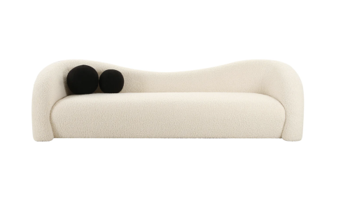 Modern curved beige sofa front view with two black round pillows on the left